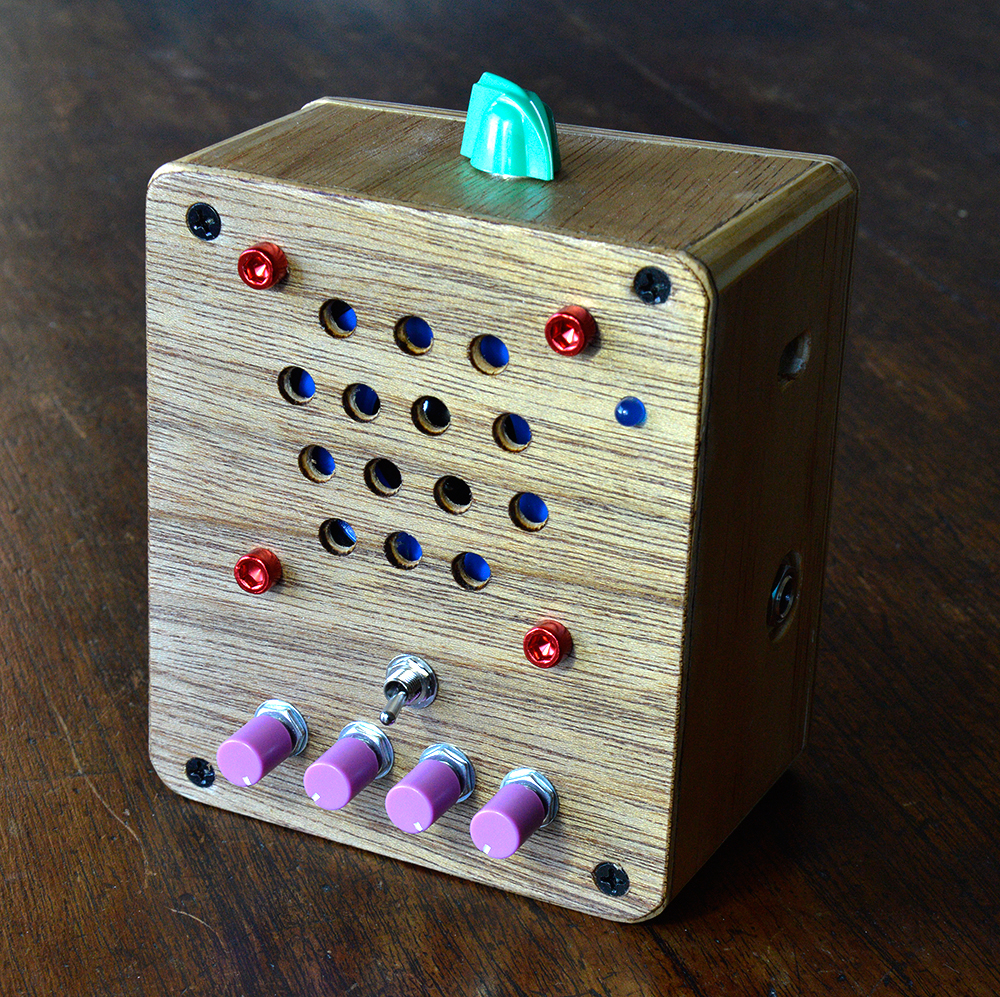 Moon Canoe Brak ver3 portable usb rechargeable practise amp with  purple knobs and overdrive switch  next to electric guitar